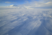 Ground storm of blowing snow over frozen McMurdo Sound with Sastrugi, Big Razorback Island and Mt Erebus, Ross Island, Antarctica