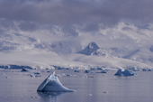 Small iceberg off Cuverville Island with Anvers Island as a backdrop. Antarctic Peninsula.