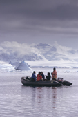 Eco tourists in a zodiac cruise amongst icebergs by Cuverville Island. Antarctic Peninsula.