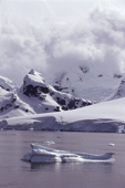 Dramatic ice capped mountain behind glacier foot on Anvers Is. Neumayer Channel. Antarctic Peninsula.