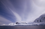 Dramatic clouds frame the glaciated coast of Anvers Island. Neumayer Channel. Antarctic Peninsula.