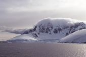 Cloud topped mountains on the coast of Graham Land. Antarctic Peninsula.