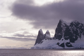 Dramatic twin peaks of False Cape Renard at the mouth of the Lemaire Channel. Antarctic Peninsula.