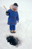 Jocelyne Immaroitok, an Inuit girl from Igloolik fishing through a hole in the ice on a lake. Baffin Island, Nunavut, Canada. 1992