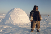 Inuit hunter Tatigat dressed in caribou skin, near an igloo he has built. Igloolik, Nunavut, Canada. 1993