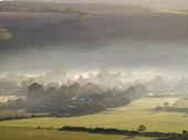 The village of Shroton in early morning mist, seen from Hambledon Hill. Dorset England