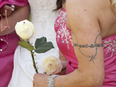 Tattoo and pretty pink frock at a celebration. UK