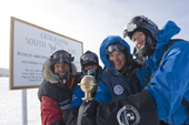 Members of the 2009 Monaco Antarctic Expedition group around the marker placed by the US Amundsen-Scott station overwintering team at the Geographic South Pole, beside the plaque to Scott and Amundsen.