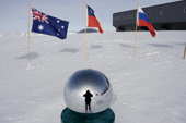Photographer reflected in the globe at the ceremonial South Pole. Amundsen-Scott South Pole Station. Antarctica