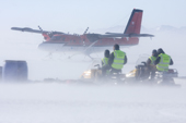 Staff stand by as a Twin Otter touches down at Patriot Hills in a high wind. Antarctica