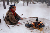 Lake Sami cooks some dried reindeer meat and coffee on his fire. Inari. Finland. 1996