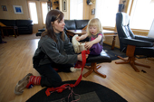 Inge Ellen, a Saami woman, helps her daughter Sara Lea put on a pair of traditional reindeer skin boots at their home near Kautokeino. Finnmark, North Norway. 2007