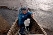 Mani, A young Innu girl, sits with a dog in a canoe during a hunting trip in Southern Labrador, Canada. 1997