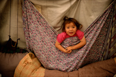 Mani, a young Innu girl, plays in a tent at her family's autumn hunting camp in Labrador, Canada. 1997