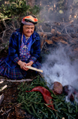 At an Innu autumn hunting camp, Enen, smokes beaver meat over an open fire. Southern Labrador, Canada. 1997