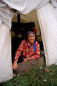 Enen, an Innu woman, sits at the entrance to a tent at an autumn hunting camp in Southern Labrador, Canada. 1997