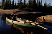 Uniam, an Innu man, using his canoe to carry firewood back to his autumn hunting camp in Southern Labrador, Canada. 1997