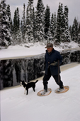 Uniam, an Innu hunter, out on snow shoes with his dog in the autumn. Southern Labrador, Canada. 1997
