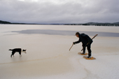 Uniam, an Innu hunter, checks the thickness of ice on a lake with his axe. Southern Labrador, Canada. 1997