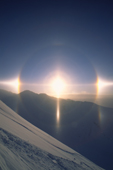 An exceptional show of ice halos. A pair of parhelia (sun dogs), the 22 degree halo, the parhelic circle, several subhelic arcs (inside the prominent 22 degree halo), a prominent lower sun pillar, a weak upper tangent arc, a pair of subparhelia, and perhaps even a hint of the subparhelic circle. Sunburst Mtn, Kenai Mountains, Alaska.