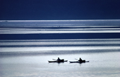 Inuit hunters using kayaks for hunting in the summer, on a stripey sea. Inglefield Bay. Thule, Northwest Greenland. 1980