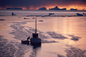 An Inuit hunter's boat among newly formed sea ice & icebergs. N.W. Greenland. 1987