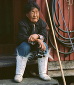 Portrait of Avortungiaq as she sits by her house in 1971. Inuit woman elder. Qaanaaq. NW Greenland. (1971)