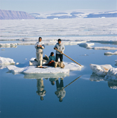 Orfik Duneq, his wife Judithe & daughter Jacobine using an ice floe as a raft to cross a wide lead in early summer. Qaanaaq. Northwest Greenland. (1971)