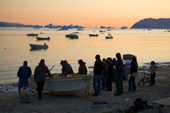 Inuit hunters on the shore after returning to Qaanaaq at sunset. Northwest Greenland. 2008