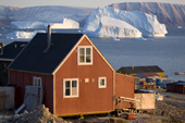 Large icebergs float in Inglefield Bay behind an Inuit hunter's home at Qaanaaq. Northwest Greenland. 2008