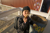 An Inuit boy plays at blowing bubbles outside the shop in Qaanaaq. Northwest Greenland. 2008