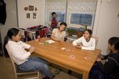 A group of Inuit girls playing cards in a house in Qaanaaq. Northwest Greenland. 2008