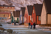 Inuit walking along one of the streets in Qaanaaq at Sunset. Northwest Greenland. 2008