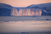 the last rays of sunlight catch the side of an iceberg at sunset in Inglefield Bay. Qaanaaq, Northwest Greenland. 2008