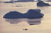 An Inuit hunter in his kayak hunting for Narwhals amongst icebergs. Savissivik, N.W. Greenland. 1991