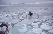 Inuit hunter jumps across  pancake ice to get ashore. Savissivik, N.W. Greenland. 1991