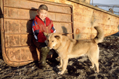 Vanya, a Chukchi boy from Inchoun, plays with a sled dog on the beach at Lavrentiya. Chukotka, Siberia, Russia. 2004