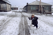 A young Chukchi boy with his bicycle on the main street of Uelen after an autumn snow fall. Chukotka, Siberia, Russia. 2004