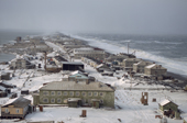 The native community of Uelen is pounded by heavy seas during an autumn storm.Less sea ice in recent years has resulted in more storm damage to the buildings. Chukotka, Siberia, Russia. 2004