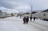 Residents of the native village of Uelen walking past the newly built Canadian style houses. Chukotka, Siberia, Russia. 2004