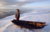 Standing by his baidarka (walrus skin boat), Yakov Vukutagin, hunts seals from the shoreline at Dezhnovka. Chukotka, Siberia, Russia. 2004