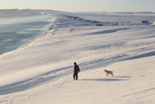 A young Chukchi hunter walks to the shoreline with his dog at Dezhnovka. Uelen Chukotka, Siberia, Russia. 2004