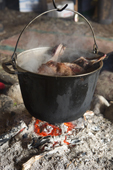 A pan of reindeer meat cooking over an open fire inside a Yaranga (tent) at a Chukchi reindeer herder's camp. Iultinsky District, Chukotka, Siberia, Russia.