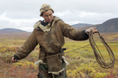 Sasha Takui, A Chukchi reindeer herder, coils up his lasso, while out working with his reindeer at their autumn pastures. Iultinsky District, Chukotka, Siberia, Russia