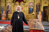 Russian Orthodox Priest, Nikolai Shvachka, stands by an icon of St Nikolai in the village Church of St. Nikolai in Pogost, Ryazan Province, Russia. 2006