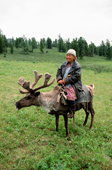 Elderly woman riding a reindeer in alpine tundra pastures. Todzhu. Republic of Tuva, Siberia. 1998