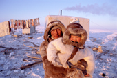 Vladimir Chuprin, a Dolgan reindeer herder, holds his young son, Artiom, outside their camp on the tundra. Taymyr, Northern Siberia, Russia. 2004