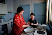 Lena Potapova helps her mother peel potatoes at home in Verkhoyansk. Yakutia, Siberia, Russia. 1999