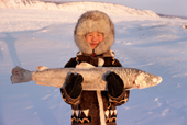Lena Slepsova, an Evenki girl from Kusur holding a frozen Nelma (white salmon) Northern Yakutia, Republic of Sakha, Russia. (2001)