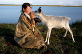 Albina, a Nenets girl, kisses one of her family's pet reindeer calves. Nadym Tundra, Yamal, Western Siberia, Russia. 2000